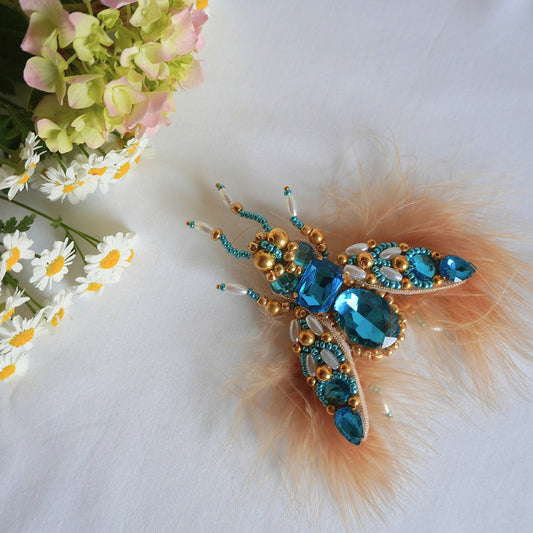 Decorative insect brooch with blue gemstones and peach feathers - TGbrooch