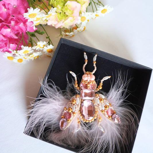 Decorative insect brooch with pink gemstones and feathers on TGbrooch black box