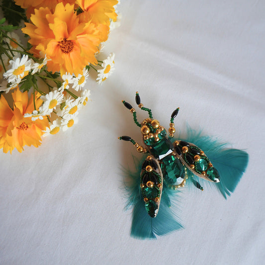 Decorative insect brooch with emerald green feathers and gold accents - TGbrooch