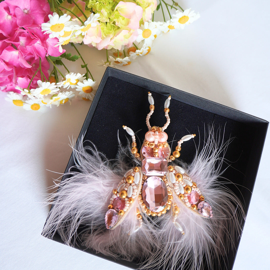Decorative insect brooch with pink gemstones and feathers on TGbrooch black box 